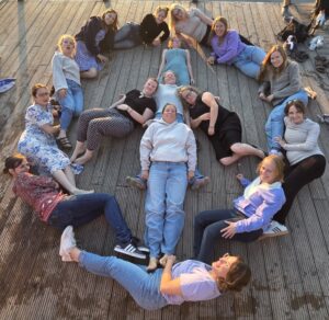 Sängerinnen des Sopran bilden liegend ein Peace-Zeichen